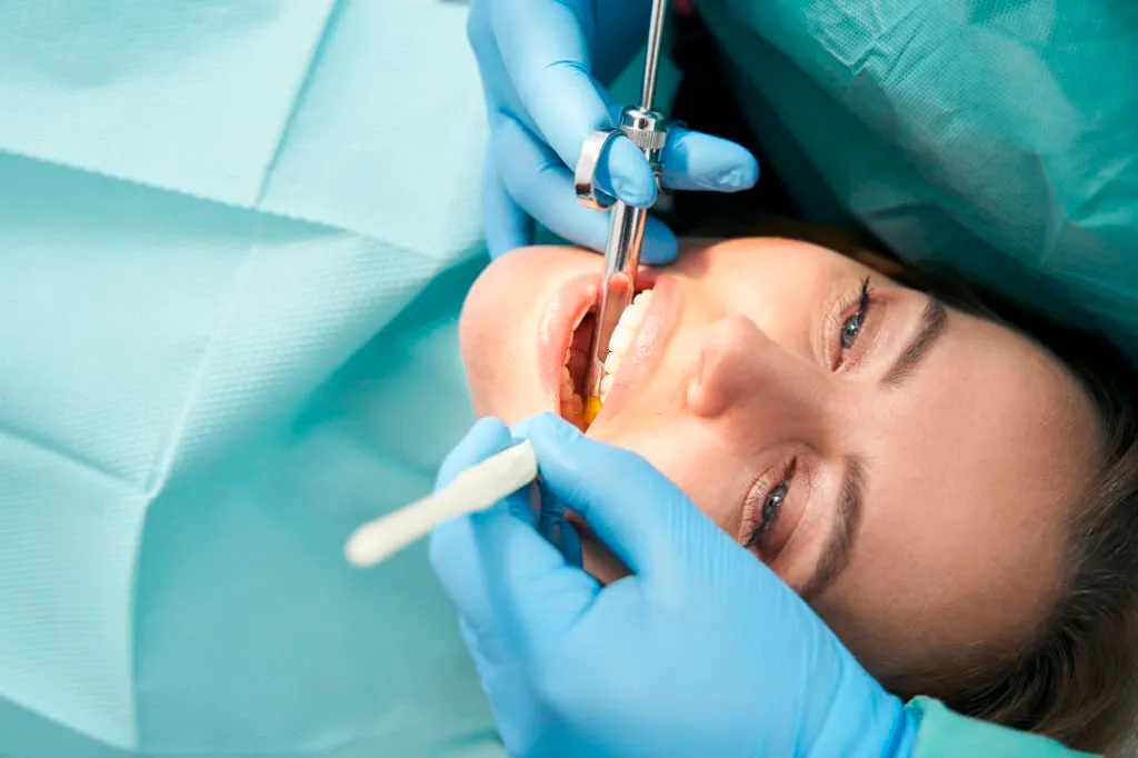 mujer en clínica dental, recibiendo tratamiento de sedación consciente
